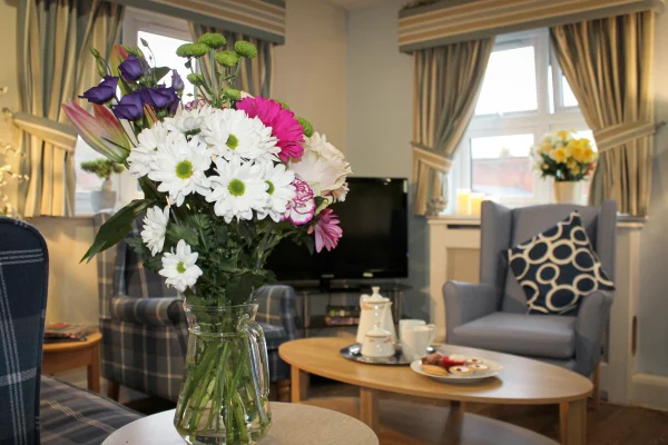 Cozy lounge room with fresh flowers and television